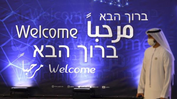 An Emirati man walks past a sign welcoming guests to a ceremony for the signing of a memorandum of understanding between the UAE and the Israeli football assosiations in Dubai, on December 14, 2020. Karim SAHIB / AFP