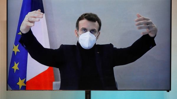 French President Emmanuel Macron, tested positive for the coronavirus disease (COVID-19), is seen on a screen as he attends by video conference a round table for the National Humanitarian Conference (NHC) at the Foreign Ministry in Paris on December 17, 2020. A host of European leaders and top French officials rushed into isolation on December 17 after President Emmanuel Macron tested positive for Covid-19, upending political agendas across the continent. CHARLES PLATIAU / POOL / AFP