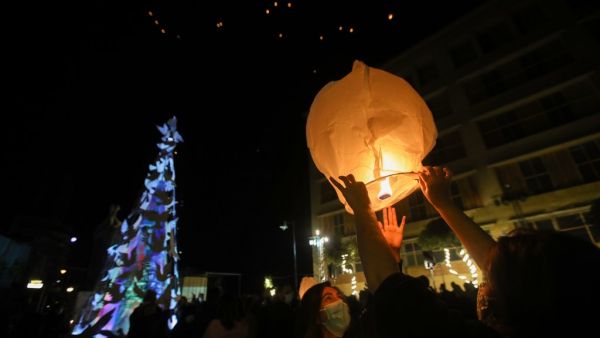 Lebanese launch lanterns in Beirut's Gemmayzeh neighbourhood on December 20, 2020, during the lighting of a Christmas tree in memory of the victims of the devastating port blast in that took place in the capital's port in August.  ANWAR AMRO / AFP