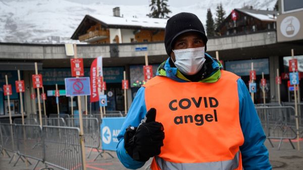 A ski lift staff identified as "Covid Angel" to remind skiers Covid-19 guidance poses on December 21, 2020 in the Swiss alpine ski resort of Verbier as Switzerland imposed an entry ban on arrivals from Britain and South Africa to stop tourism from countries following the discovery there of new, more contagious variants of Covid-19.  Fabrice COFFRINI / AFP