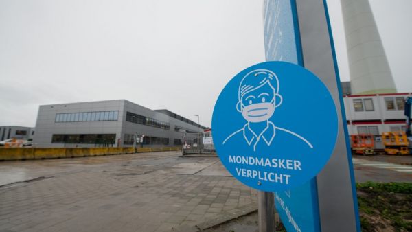 A picture shows a sign reading "Mandatory face mask" at the US pharmaceutical giant Pfizer plant in Puurs, northeast Belgium, on December 23, 2020, on the day trucks carrying the first batches of the Pfizer-BioNTech Covid-19 (novel coronavirus) vaccines for EU citizens left the plant, ahead of a rollout across the 27-nation bloc. Member states are set to start issuing the Pfizer-BioNTech inoculations from December 27 after the European Medicines Agency (EMA) Union's medicines regulator gave the green light 