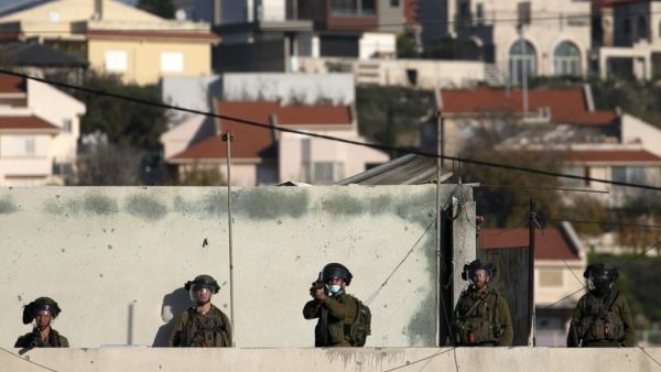 Israeli security forces keep watch as Palestinian youths throw stones during a protest in the village of Kfar Qaddum in the occupied West Bank, on December 26, 2020. JAAFAR ASHTIYEH / AFP