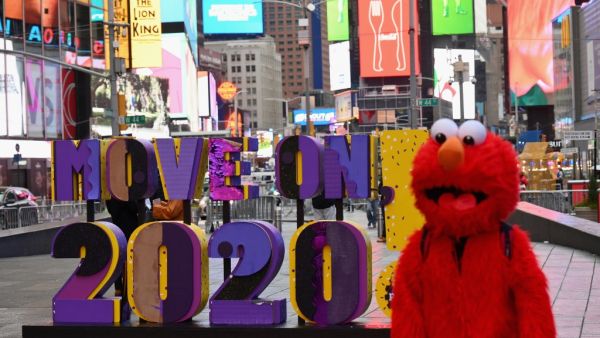 A person dressed as Elmo walks past a sign reading 'Move On 2020!' at Times Square on December 28, 2020 in New York City. Angela Weiss / AFP