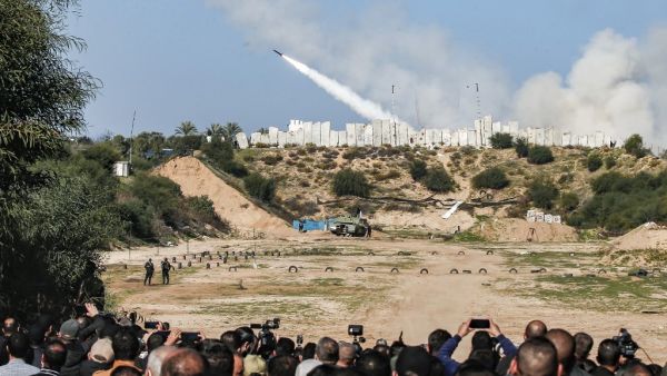 People watch as rockets are fired during a military drill by Palestinian Islamist movement Hamas and other Palestinian armed factions in Gaza City on December 29, 2020. MAHMUD HAMS / AFP