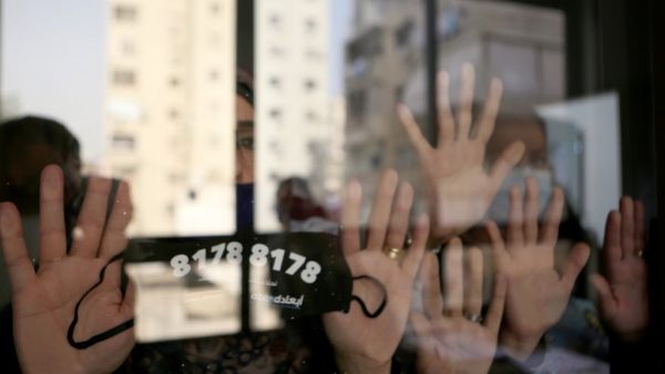 Lebanese woman display a protective mask hiding a hot number distributed by the NGO ABAAD in Beirut on 08 December 2020. (PATRICK BAZ / ABAAD)