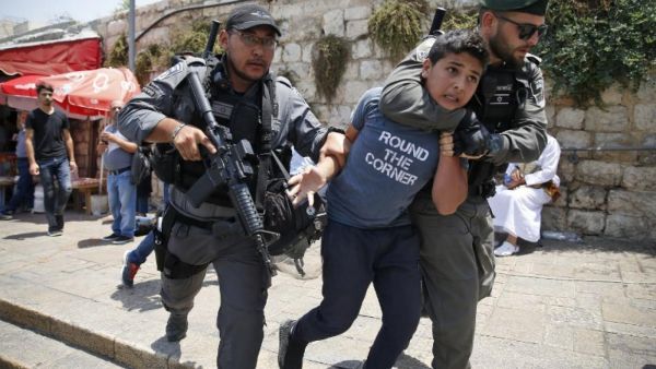Israeli border guards detain a Palestinian boy during a demonstration outside the Lions Gate, a main entrance to Al-Aqsa mosque compound on 17 July 2017 (AFP)