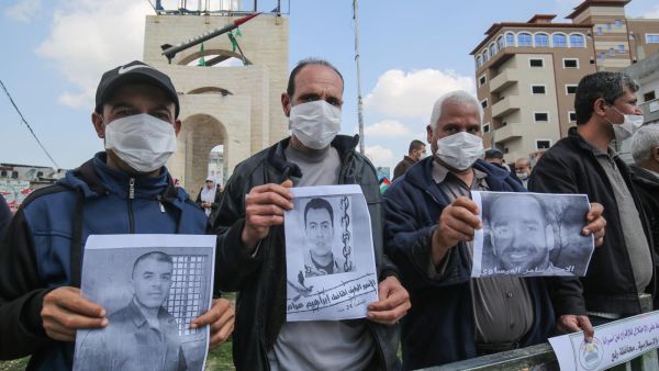 Palestinians, wearing protective masks amid fears of the spread of the novel coronavirus, take part in a protest in solidarity with Palestinian prisoners in Israeli jails, 16 March (AFP)