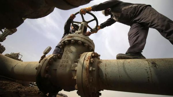 موظفون عراقيون يفتحون صماماً في منشأة نفطية في حقل نهر بن عمر للغاز الطبيعي 