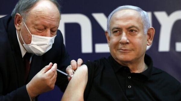 Prime Minister Benjamin Netanyahu receives a coronavirus vaccine, from his personal physician Dr. Tzvi Berkovitz, at Sheba Medical Center in Ramat Gan, on December 19, 2020, becoming the first Israeli to get the vaccine. (Amir Cohen/Pool/AFP)