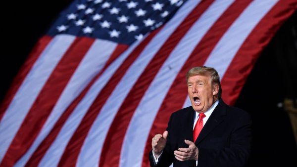 US President Donald Trump claps during a rally in support of Republican incumbent senators Kelly Loeffler and David Perdue ahead of Senate runoff in Dalton, Georgia on January 4, 2021. President Donald Trump, still seeking ways to reverse his election defeat, and President-elect Joe Biden converge on Georgia on Monday for dueling rallies on the eve of runoff votes that will decide control of the US Senate. MANDEL NGAN / AFP