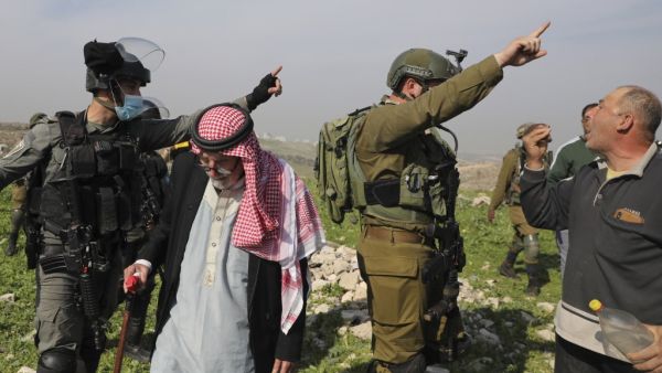 Palestinian farmers protest after Israeli security forces uprooted olive trees reportedly located within the area C (where Israel retains control, including over planning and construction) in the West Bank village of Deir Ballut on January 6, 2021. JAAFAR ASHTIYEH / AFP