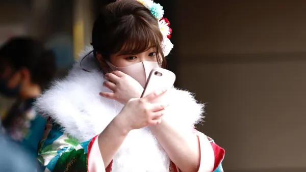A twenty-year-old woman dressed in a kimono waits at the entrance of Todoroki Arena to attend the "Coming-of-Age Day" celebration ceremony in Kawasaki, Kanagawa prefecture on January 11, 2021 under a state of emergency over the Covid-19 coronavirus pandemic. Behrouz MEHRI / AFP