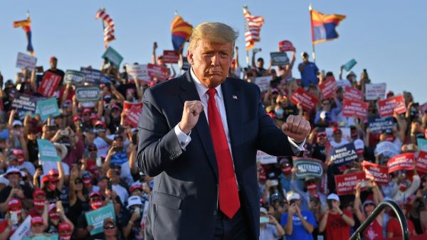 In this file photo taken on October 19, 2020 US President Donald Trump dances as he leaves a rally at Tucson International Airport in Tucson, Arizona. MANDEL NGAN / AFP