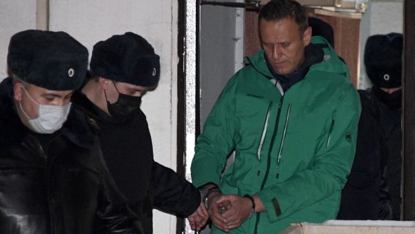 Opposition leader Alexei Navalny is escorted out of a police station in Khimki, outside Moscow, following the court ruling that ordered him jailed for 30 days. Kremlin critic Alexei Navalny on Monday urged Russians to stage mass anti-government protests during a court hearing after his arrest on arrival in Moscow from Germany. Alexander NEMENOV / AFP