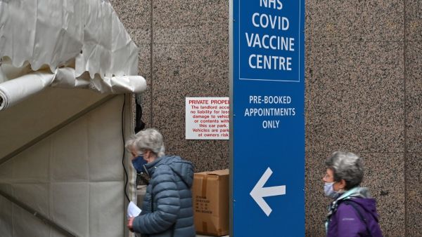 People attend a Covid-19 vaccination centre in Wembley, northwest London, on January 19, 2021. Britain on January 18 extended its coronavirus vaccination campaign to people over the age of 70, as new, tougher restrictions for all arrivals to the country came into force. JUSTIN TALLIS / AFP