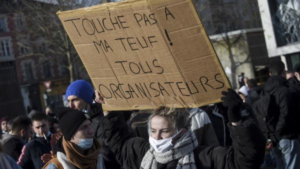 A protestor holds a placard reading "Don't touch my party! All organizers " during a demonstration to support organizers of an illegal New Year rave that saw 2,400 people defy virus rules in Rennes, western France, on January 23, 2021. The wildcat rave party over the New Year in the Brittany region in northwestern France shocked the country as people continue to observe strict bans on gatherings to battle the coronavirus. Sebastien SALOM-GOMIS / AFP