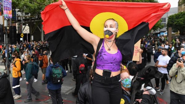 People hold placards as thousands of people attend an Australia Day protest in Melbourne in January 26, 2021. William WEST / AFP