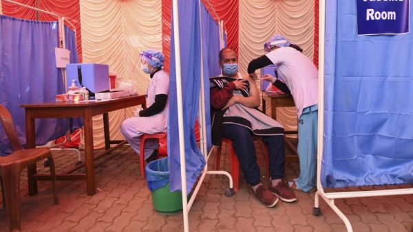 A health worker receives a dose of Covishield, AstraZeneca-Oxford's COVID-19 coronavirus vaccine made by local partner Serum Institute of India, at Patan Hospital near Kathmandu on January 27, 2021. PRAKASH MATHEMA / AFP