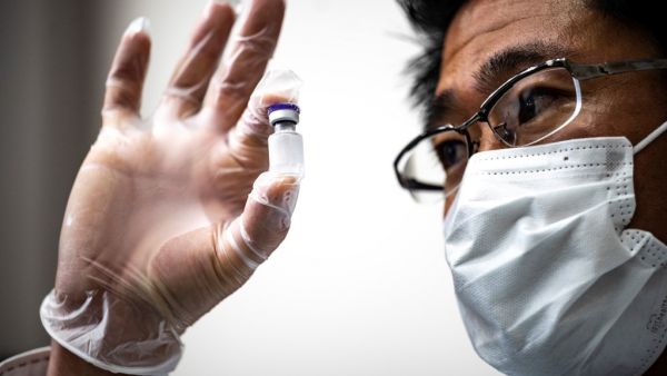 A medical personnel presents a containers with water, which are used to preserve the vaccinnes in a deep freezer during a Covid-19 coronavirus vaccination drill at the Kawasaki City College of Nursing in Kawasaki on January 27, 2021. Philip FONG / AFP