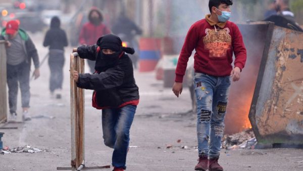 A Lebanese protester pushes a metal barricade during ongoing demonstrations in Lebanon's northern port city of Tripoli on January 27, 2021, as anger grows over a total lockdown aimed at stemming an unprecedented spike in coronavirus cases. Fathi AL-MASRI / AFP