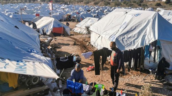 In this file photo taken on December 19, 2020 a migrant couple hang out their laundry outside their tent, in the new refugee camp of Kara Tepe, in the Greek island of Lesbos. The UN voiced alarm on January 28, 2021 at increasingly frequent pushbacks and expulsions of refugees at Europe's borders, warning that the very idea of asylum itself was under attack on the continent. Anthi PAZIANOU / AFP