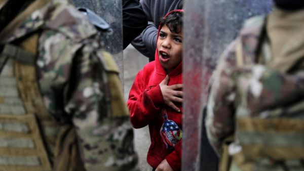 A boy gestures as Lebanese anti-government protesters confront security forces while going around the homes of deputies and government officials in the northern port city of Tripoli to protest the economic situation and their role in leading the country to crisis, on January 28, 2021. Tripoli was already one of Lebanon's poorest areas before the coronavirus pandemic piled new misery onto a chronic economic crisis. Many of its residents have been left without an income since Lebanon imposed a full lockdown e