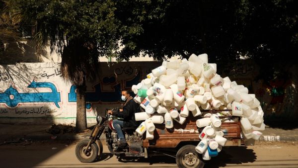 A Palestinian man rides his vehicle loaded with empty plastic containers that were collected from the street for recycling, in Gaza City, on January 31, 2021. MOHAMMED ABED / AFP