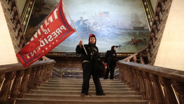  A protester holds a Trump flag inside the US Capitol Building near the Senate Chamber on January 06, 2021 in Washington, DC. Congress held a joint session today to ratify President-elect Joe Biden's 306-232 Electoral College win over President Donald Trump. A group of Republican senators said they would reject the Electoral College votes of several states unless Congress appointed a commission to audit the election results. Win McNamee/Getty Images/AFP WIN MCNAMEE / GETTY IMAGES NORTH AMERICA / Getty Image