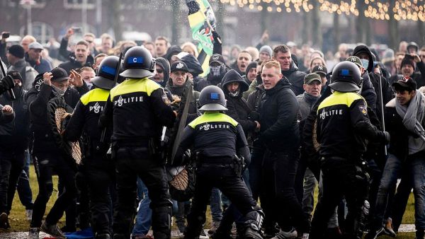 Hundreds of protestors not wearing face masks clash with Dutch riot police at an illegal protest against the Netherlands' new lockdown measures in Museumplein today. (AFP)