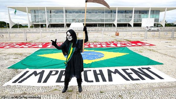 A demonstrator representing the grim reaper standing in front of an 'impeachment' banner takes part in a protest against Brazil's President Jair Bolsonaro measures to confront the COVID-19 coronavirus pandemic, January 17. (AFP)