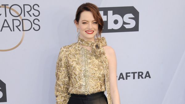 Emma Stone has been spotted cradling her burgeoning belly while out on a walk in Los Angeles. 