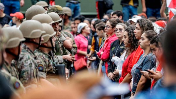 Female protesters stand in a line before Lebanese army soldiers during a demonstration on the seventh day of unrest against tax increases and official corruption, in Zouk Mosbeh, north of Beirut. AFP