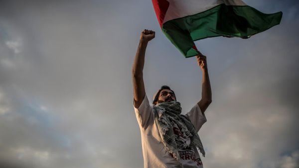 A man waves a Palestinian flag during a protest to mark Nakba Day (AFP)