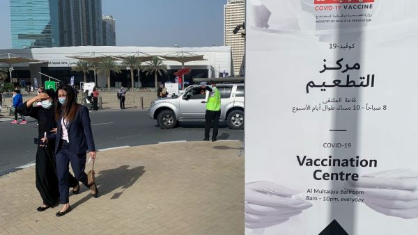 People arrive to a designated COVID-19 vaccination center at Dubai's financial center district, in the United Arab Emirates, on January 24, 2021. The emirate of Dubai has said it was slowing down its rollout of the Pfizer-BioNTech coronavirus vaccine due to a temporary delay in global deliveries. Giuseppe CACACE / AFP