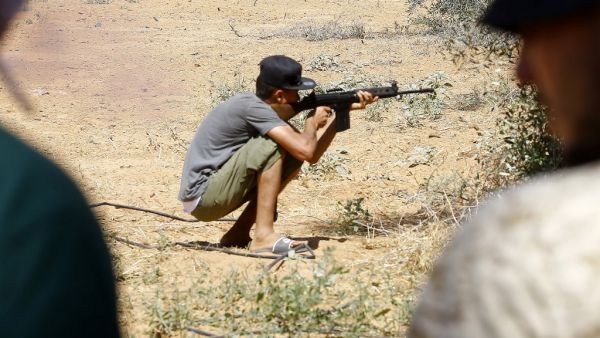 In this file photo taken on June 19, 2019 a fighter loyal to the internationally-recognised Libyan Government of National Accord (GNA) holds a rifle from a position in the al-Sawani area south of the Libyan capital Tripoli during clashes with forces loyal to strongman Khalifa Haftar. Mahmud TURKIA / AFP
