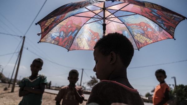 An Eritrean refugee child stands under an umbrella at Mai Aini Refugee camp, in Ethiopia, on January 30, 2021. Eritrean refugees in Ethiopia fear their suffering may not be over, as Prime Minister Abiy Ahmed strains to end a brutal conflict in the northern region of Tigray that has rendered them uniquely vulnerable. Nearly 100,000 refugees from Eritrea, an oppressive, authoritarian nation bordering Ethiopia to the north, were registered in four camps in Tigray when fighting erupted in November between Abiy's government and the regional ruling party, the Tigray People's Liberation Front (TPLF). EDUARDO SOTERAS / AFP An Eritrean refugee child stands under an umbrella at Mai Aini Refugee camp, in Ethiopia, on January 30, 2021. Eritrean refugees in Ethiopia fear their suffering may not be over, as Prime Minister Abiy Ahmed strains to end a brutal conflict in the northern region of Tigray that has rendered them uniquely vulnerable. Nearly 100,000 refugees from Eritrea, an oppressive, authoritarian nation bordering Ethiopia to the north, were registered in four camps in Tigray when fighting erupted in November between Abiy'
