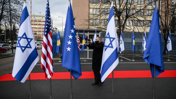 A Kosovo Albanian man takes pictures of Israeli's, US and Kosovo's flag displayed during a ceremony at the headquarters of the Foreign Ministry in Pristina on February 1, 2021. Kosovo and Israel established diplomatic ties on February 1, 2021, with the Muslim-majority territory recognising Jerusalem as the Jewish state's capital, putting it at odds with the rest of the Islamic world. In a ceremony held over Zoom in Jerusalem and Pristina, Israeli Foreign Minister and his counterpart from Kosovo signed a joi
