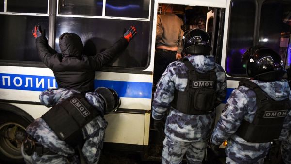A riot police officer searches a detained man during a protest against a court ruling ordered Russian opposition leader Alexei Navalny jailed for nearly three years, in downtown Moscow early on February 3, 2021. NATALIA KOLESNIKOVA / AFP