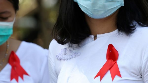Department of Agriculture staff wear red ribbons on their uniforms in Naypyidaw on February 4, 2021 after calls for protest went out on social media, as Myanmar's ousted leader Aung San Suu Kyi was formally charged on February 3 two days after she was detained in a military coup. STR / AFP