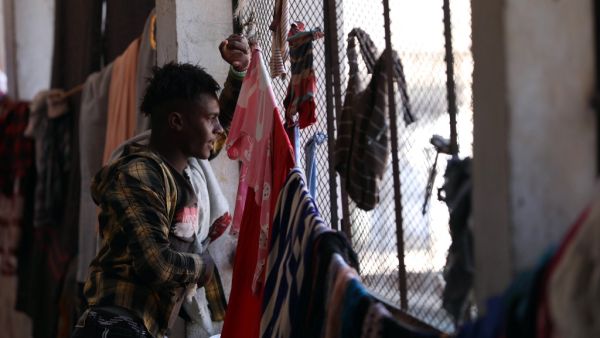 A man looks out of a window inside a school building for displaced Yemenis who fled fighting between Huthi rebels and the Saudi-backed government forces, in the town of al-Turba in Taez governorate on February 4, 2021. AHMAD AL-BASHA / AFP