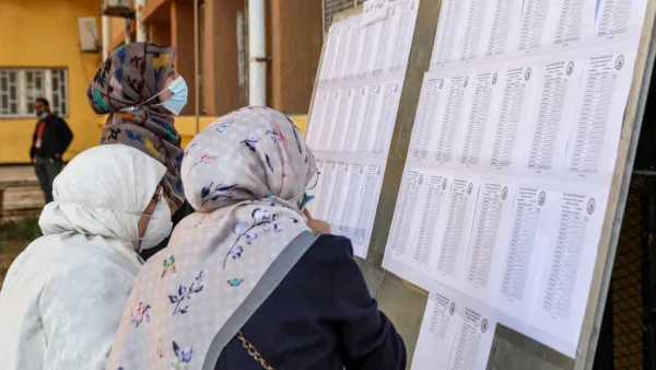 A mask-clad voter checks the electoral lists upon arriving to vote during an election for the Tripoli Municipal Council, in Libya's capital on February 6, 2021. Mahmud TURKIA / AFP