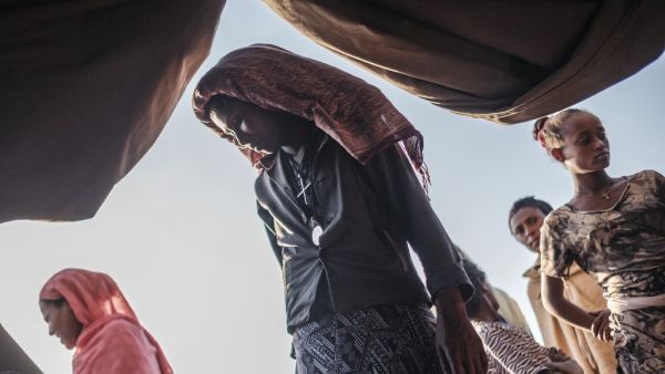 Internally Displaced People (IDP), fleeing from violence in the Metekel zone in Western Ethiopia, gather outside a tent where clothes are being distributed at a camp in Chagni, Ethiopia, on January 27, 2021. Inter-ethnic violence in Ethiopia's west -- concentrated in a lowland area known as Metekel -- predates a brutal three-month-old conflict farther north pitting Prime Minister Abiy Ahmed's government against the former ruling party of the Tigray region.  EDUARDO SOTERAS / AFP Internally Displaced People (IDP), fleeing from violence in the Metekel zone in Western Ethiopia, gather outside a tent where clothes are being distributed at a camp in Chagni, Ethiopia, on January 27, 2021. Inter-ethnic violence in Ethiopia's west -- concentrated in a lowland area known as Metekel -- predates a brutal three-month-old conflict farther north pitting Prime Minister Abiy Ahmed's government against the former ruling party of the Tigray region.  EDUARDO SOTERAS / AFP