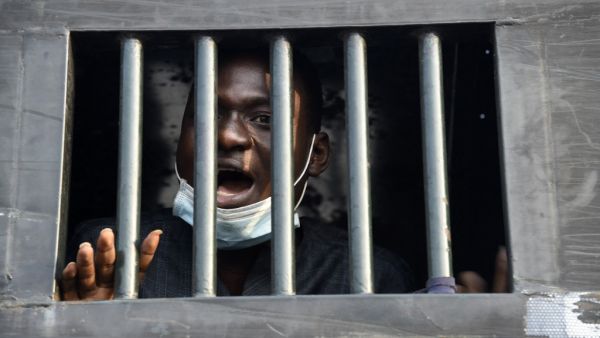 Twenty four-year-old protester Damilare Adenola speaks from a black truck as he is detained after being arrested along with 13 other protesters during a demonstration against police brutality, at the Lekki tollgate in Lagos on February 13, 2021. Nigerian police arrested a small group of protesters in Lagos after they tried to hold a rally demanding justice for victims of a deadly shooting during demonstrations last year. Activists had called for new protests after a judicial panel authorised the reopening o