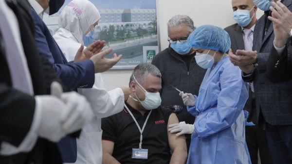 Head of the intensive care unit at Lebanon's Rafik Hariri Hospital battling the coronavirus, Mahmoud Hassoun, receives the first jab of the COVID-19 Pfizer/BioNTech vaccine at the hospital premises as the country kickstarts its inoculation campaign, in the capital Beirut, on February 14, 2021. Lebanon gave its first COVID-19 vaccine dose to a doctor, as it started inoculation it hopes will keep the pandemic in check amid a deepening economic crisis. ANWAR AMRO / AFP Head of the intensive care unit at Lebanon's Rafik Hariri Hospital battling the coronavirus, Mahmoud Hassoun, receives the first jab of the COVID-19 Pfizer/BioNTech vaccine at the hospital premises as the country kickstarts its inoculation campaign, in the capital Beirut, on February 14, 2021. Lebanon gave its first COVID-19 vaccine dose to a doctor, as it started inoculation it hopes will keep the pandemic in check amid a deepening economic crisis. ANWAR AMRO / AFP