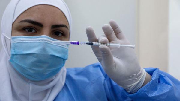 A member of the healthcare staff prepares a dose of the COVID-19 Pfizer/BioNTech vaccine at Lebanon's Rafik Hariri Hospital in the capital Beirut, on February 14, 2021, as the country kickstarts its inoculation campaign. Lebanon gave its first COVID-19 vaccine dose to a doctor, as it started inoculation it hopes will keep the pandemic in check amid a deepening economic crisis. ANWAR AMRO / AFP