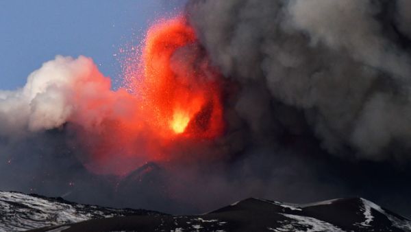 This photo obtained from Italian news agency ANSA shows the Etna volcano in Catania, Sicily, on February 16, 2021 during a spectacular eruption and a strong explosive activity from the south-east crater and the emission of a high cloud of lava ash that disperses towards the south. Handout / ANSA / AFP