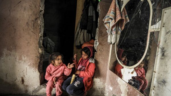Palestinian girls sit together next to a wall-mounted mirror in their home in an impoverished neighbourhood during stormy weather in Gaza City on February 17, 2021. MAHMUD HAMS / AFP