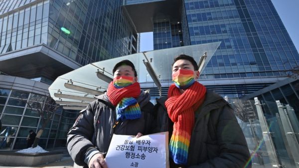 South Korean same-sex couple So Seong-wook (L) and Kim Yong-min (R) attend a press conference as they file a lawsuit against the National Health Insurance Service for their dependent family status, at the Seoul Administrative Court in Seoul on February 18, 2021. Jung Yeon-je / AFP