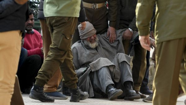 A relative (C) of a slain policeman griefs before a wreath laying ceremony at a police headquarter in Srinagar on February 19, 2021 after unidentified gunmen killed two police personnel in Srinagar. TAUSEEF MUSTAFA / AFP