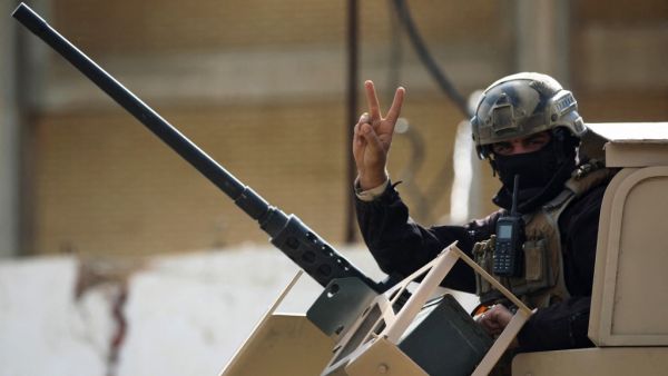 A member of the Iraqi force gestures during a search of the area in Tarmiyah, 35 kilometres (20 miles) north of Baghdad on February 20, 2021, following clashes with Islamic State group fighters. Iraqi security forces clashed with the Islamic State group north of Baghdad, leaving at least five jihadists and two security personnel dead. A joint force of army troops and state-sponsored tribal fighters raided an IS hideout in the leafy plains of Tarmiyah, according to a statement from the military. AFP